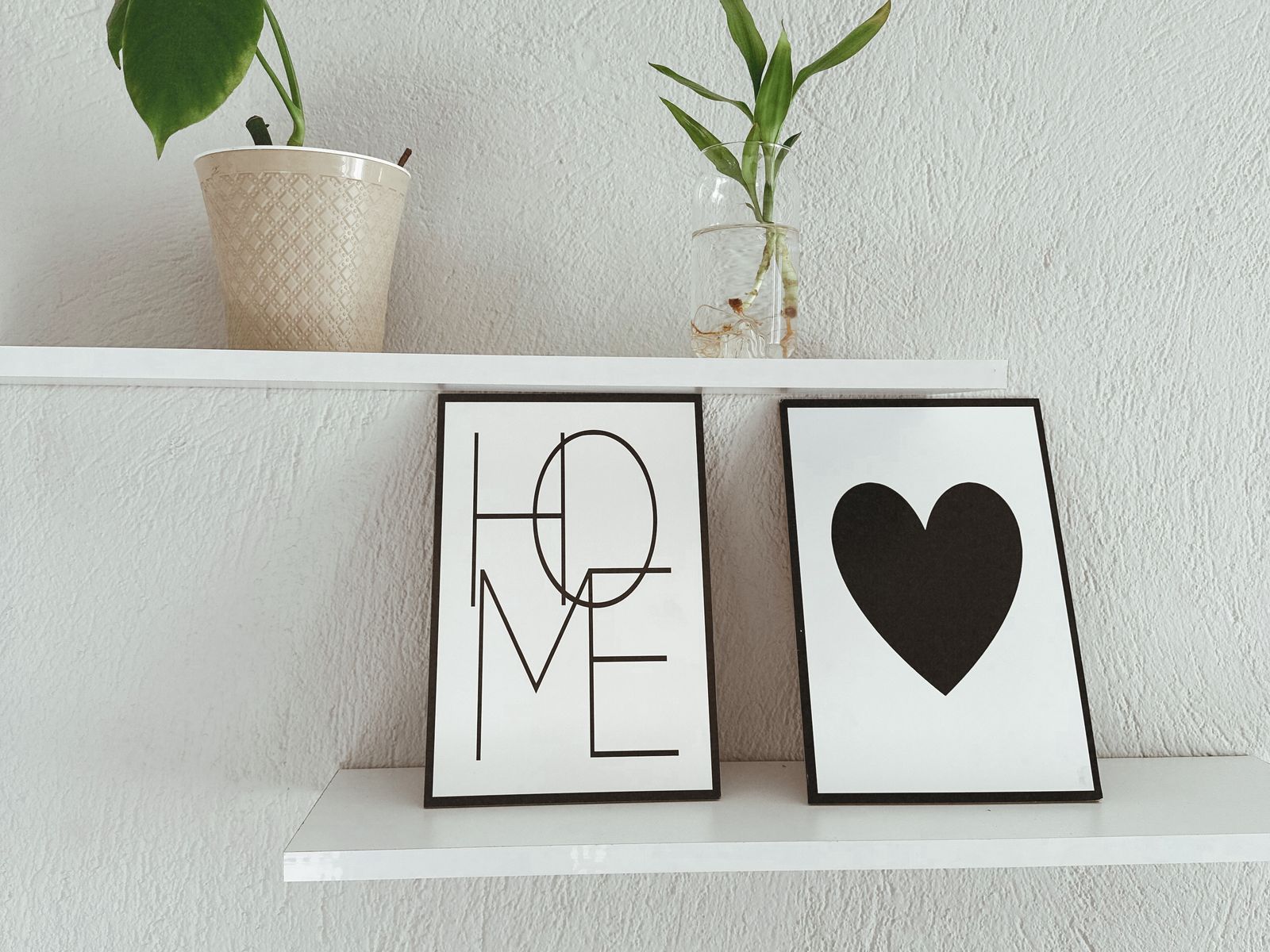 Adhesive floating shelf installed without drilling holding small plants and art