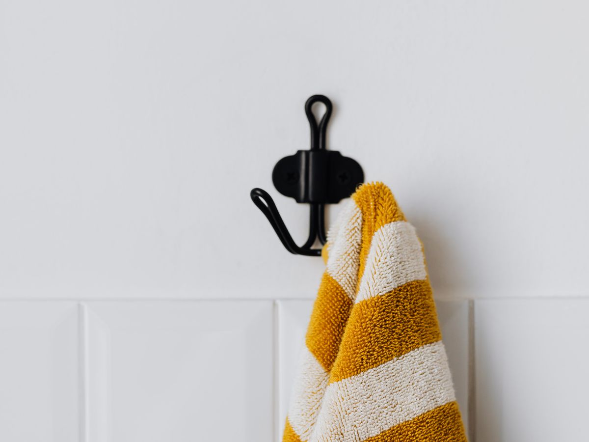An adhesive mounting hook on a tiled wall, no-drill hardware for hanging items