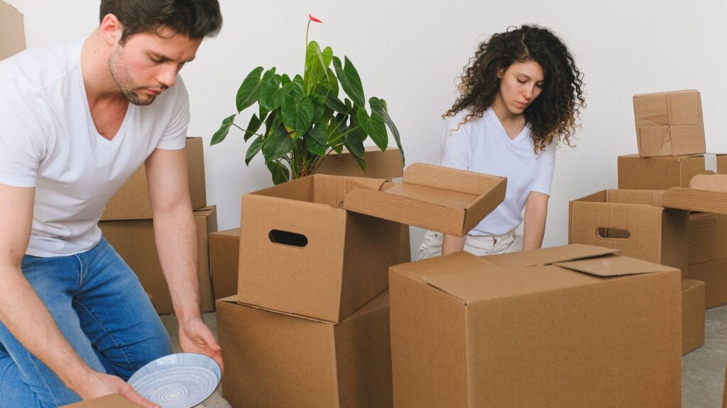 A couple packing boxes while following an apartment moving checklist