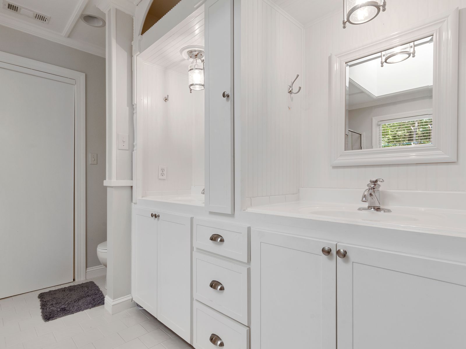 White bathroom vanity with a cabinet offering under the sink storage