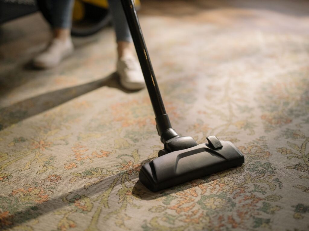 Vacuuming a rental carpet to treat carpet stains before move-out