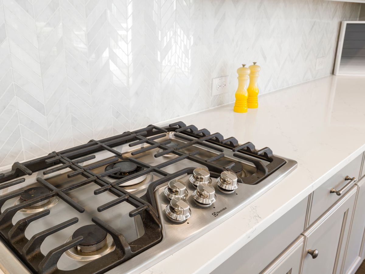Clean kitchen stovetop and tiled backsplash detail