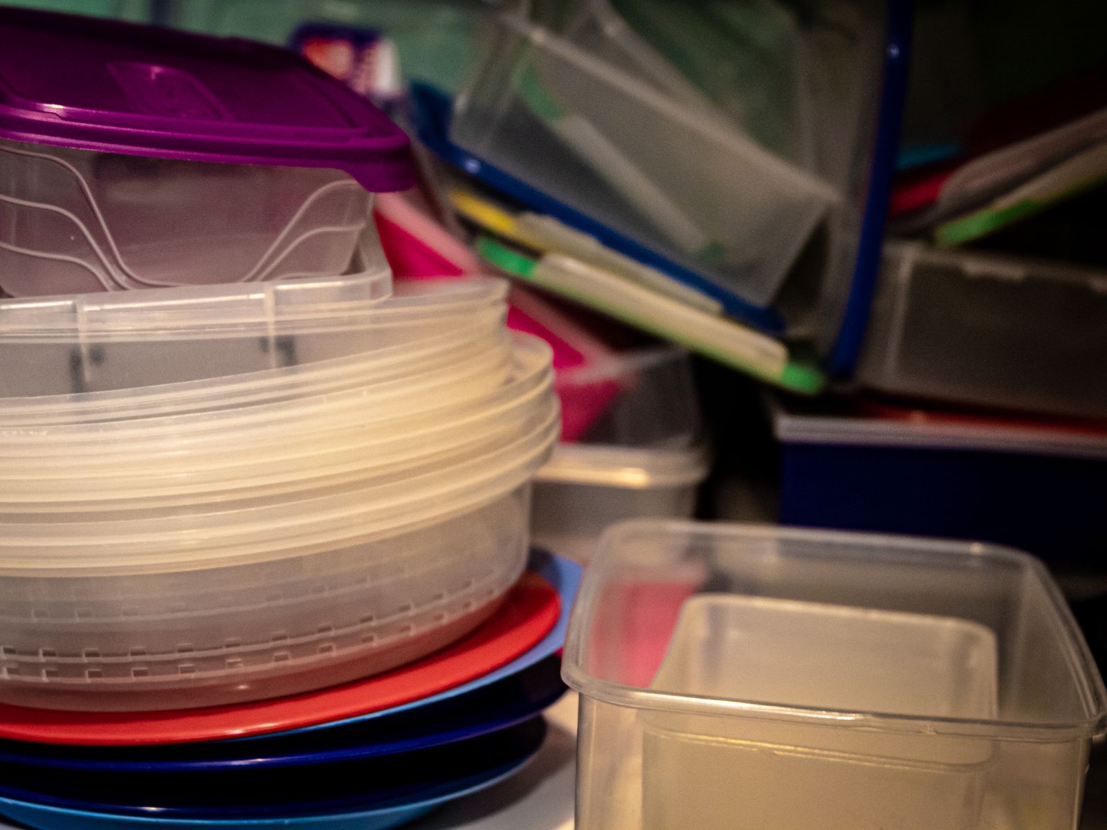 Stacked clear plastic storage containers for organizing under the sink