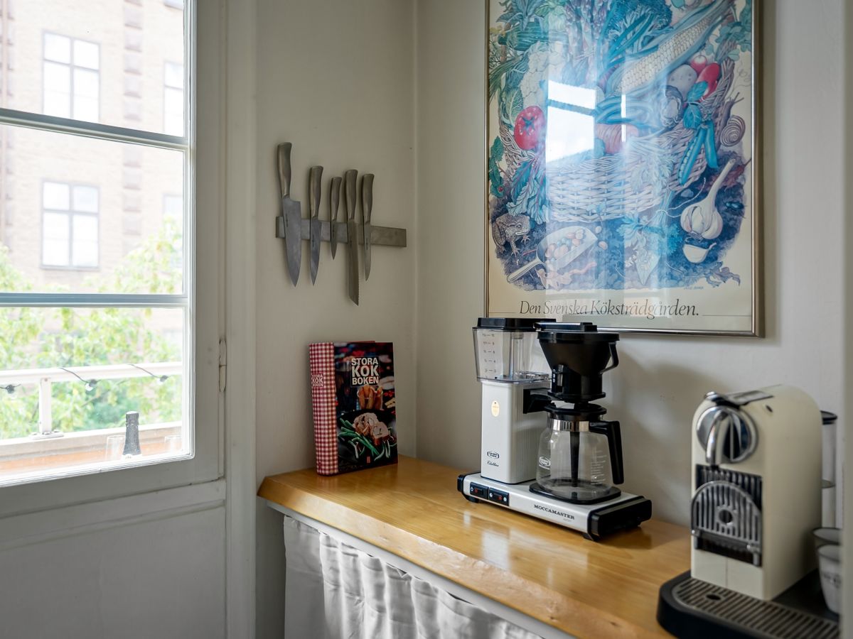 Coffee maker set up on a wooden counter by a window as a daily-life anchor zone in a new rental