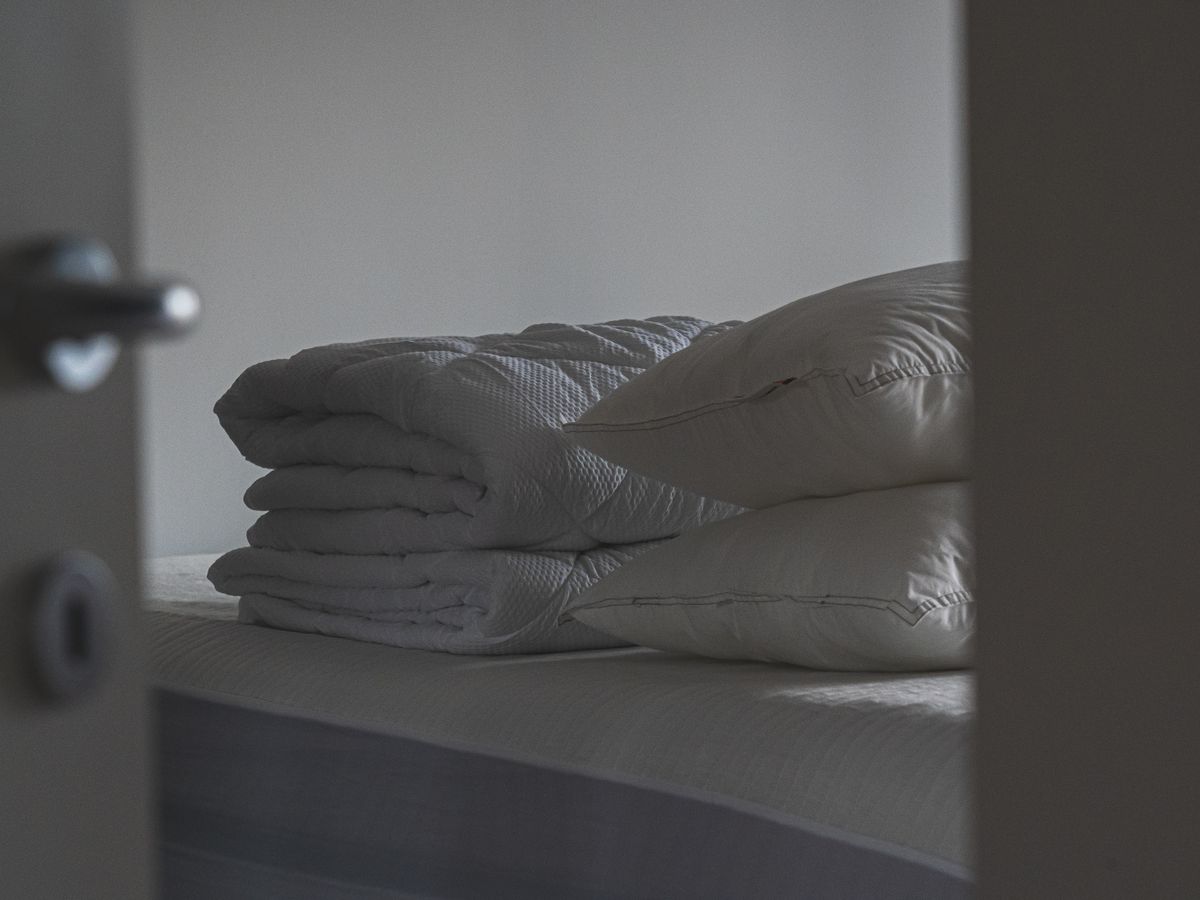 A neatly made bed with soft pillows as a first-night comfort anchor