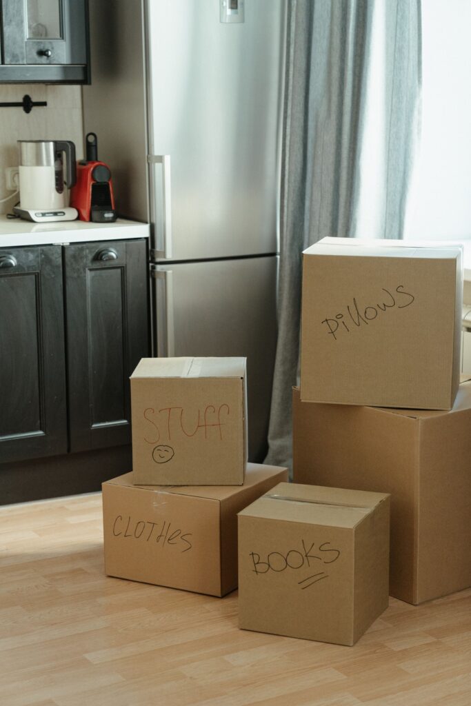 Cardboard moving boxes stacked in an apartment as someone prepares to downsize when moving