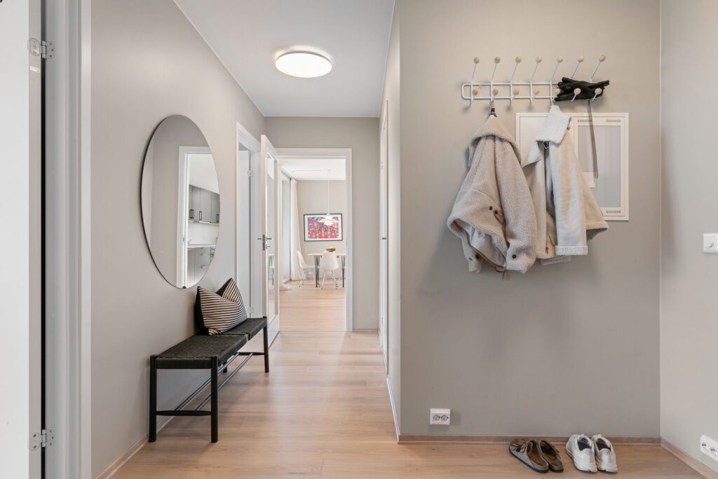 Entryway organization in a small apartment with coats, shoes, and a mirror by the door