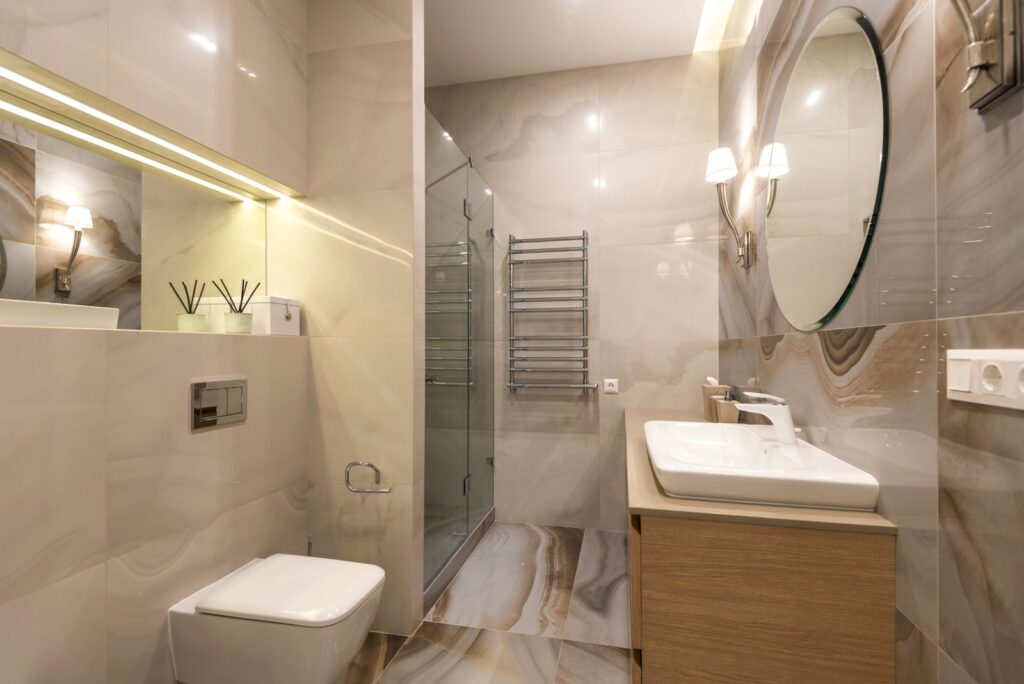 Elegant rental bathroom with marble tiles and a large mirror that looks expensive