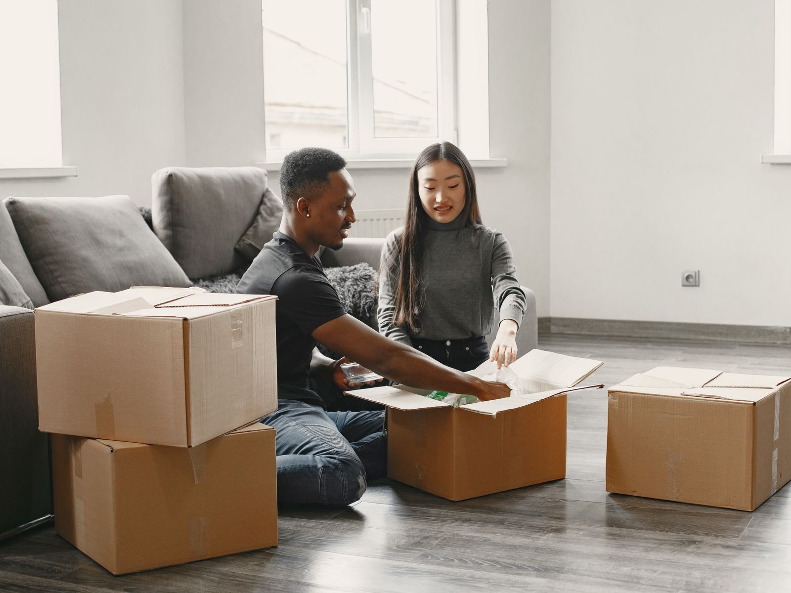 Couple setting up a living room with first apartment essentials