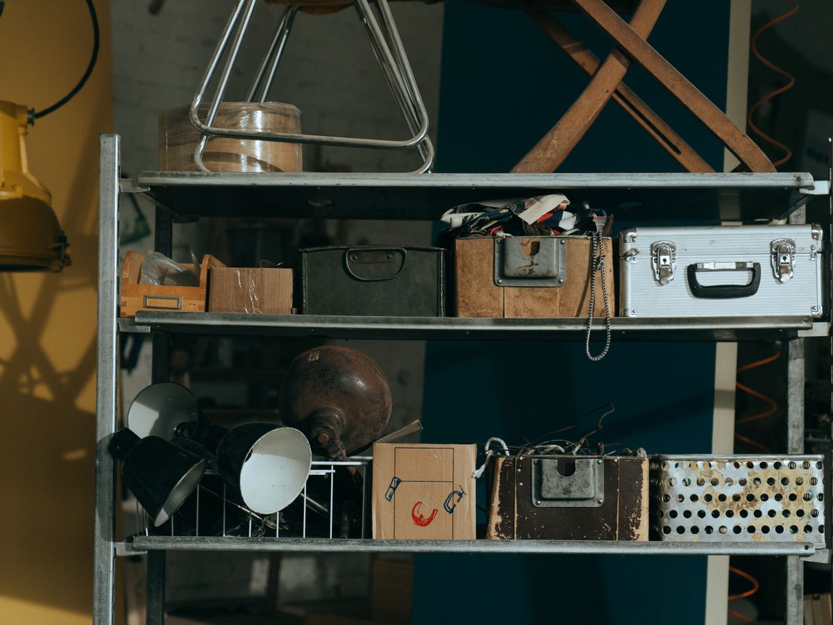 Freestanding workshop shelf holding organized storage items and bins