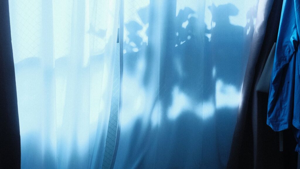 White curtains hung without drilling framing a bright apartment window