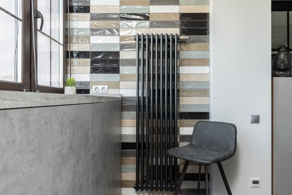 Living room interior with a radiator along a tiled wall in a rental