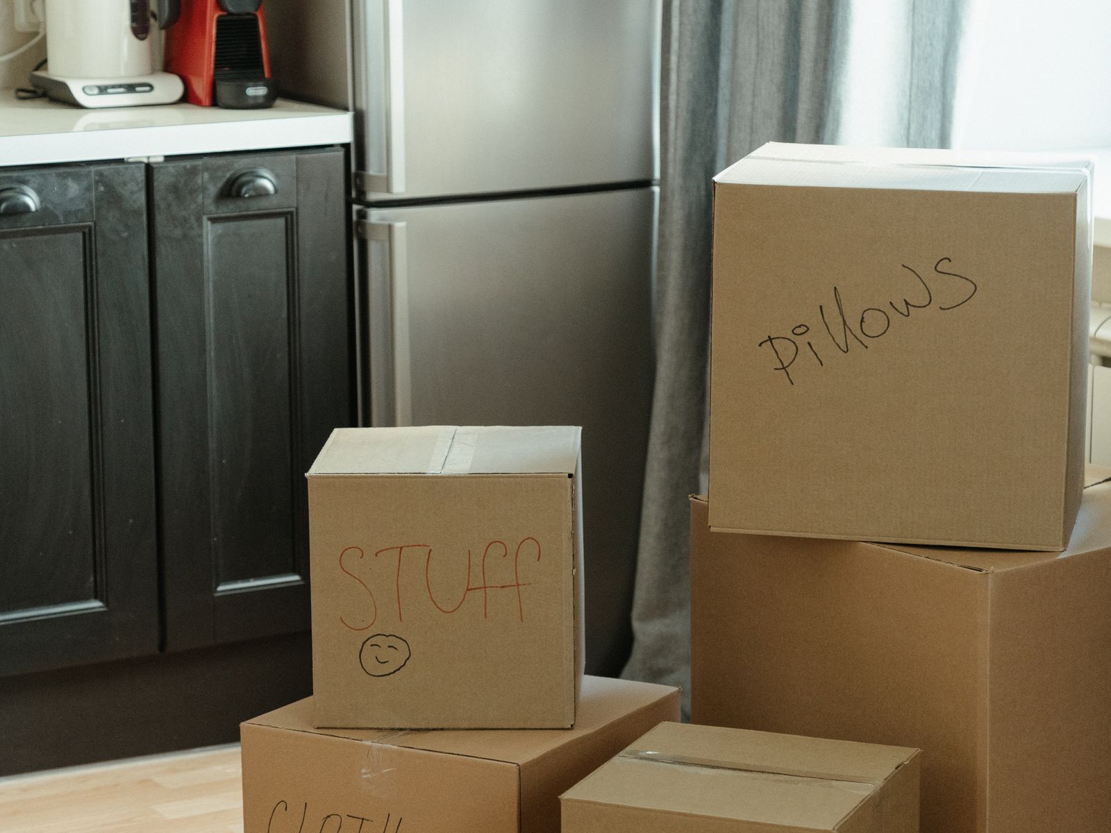 Moving boxes labeled by room following an apartment moving checklist