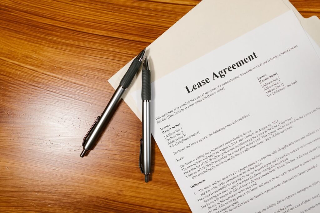 Lease agreement document with pens on a desk, showing what to check for normal wear and tear clauses