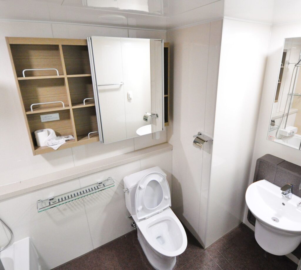 Rental bathroom with freestanding storage shelves added without drilling