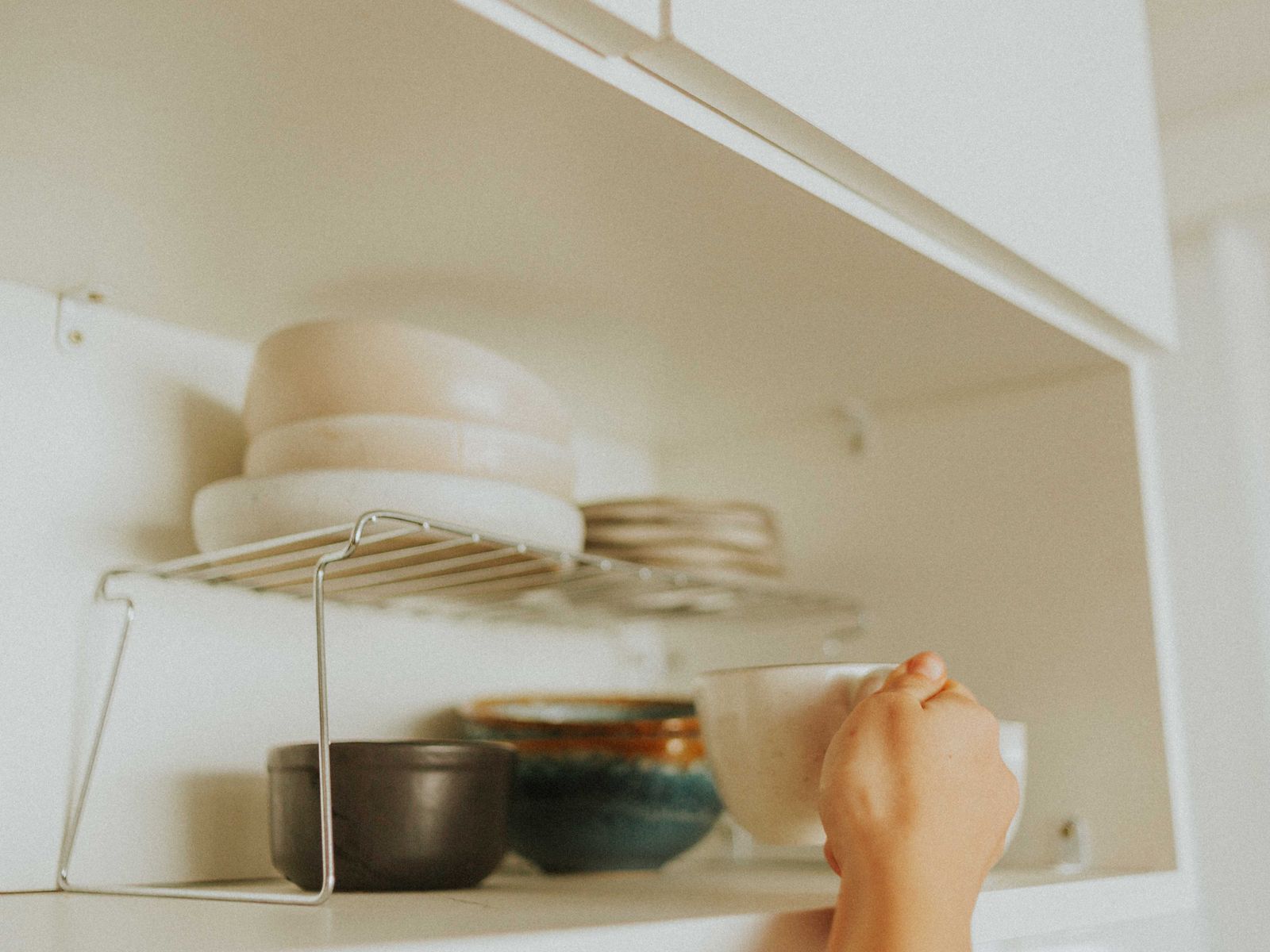 Neatly stacked dishes inside an organized rental kitchen cabinet