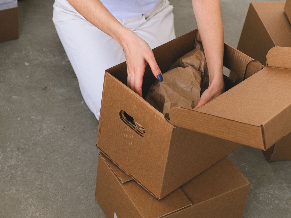 Woman organizing labeled cardboard boxes while preparing to move