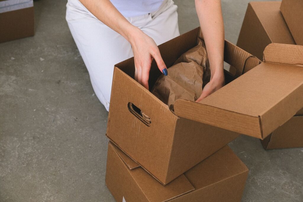 Renter packing wrapped items into a box to pack an apartment in one weekend