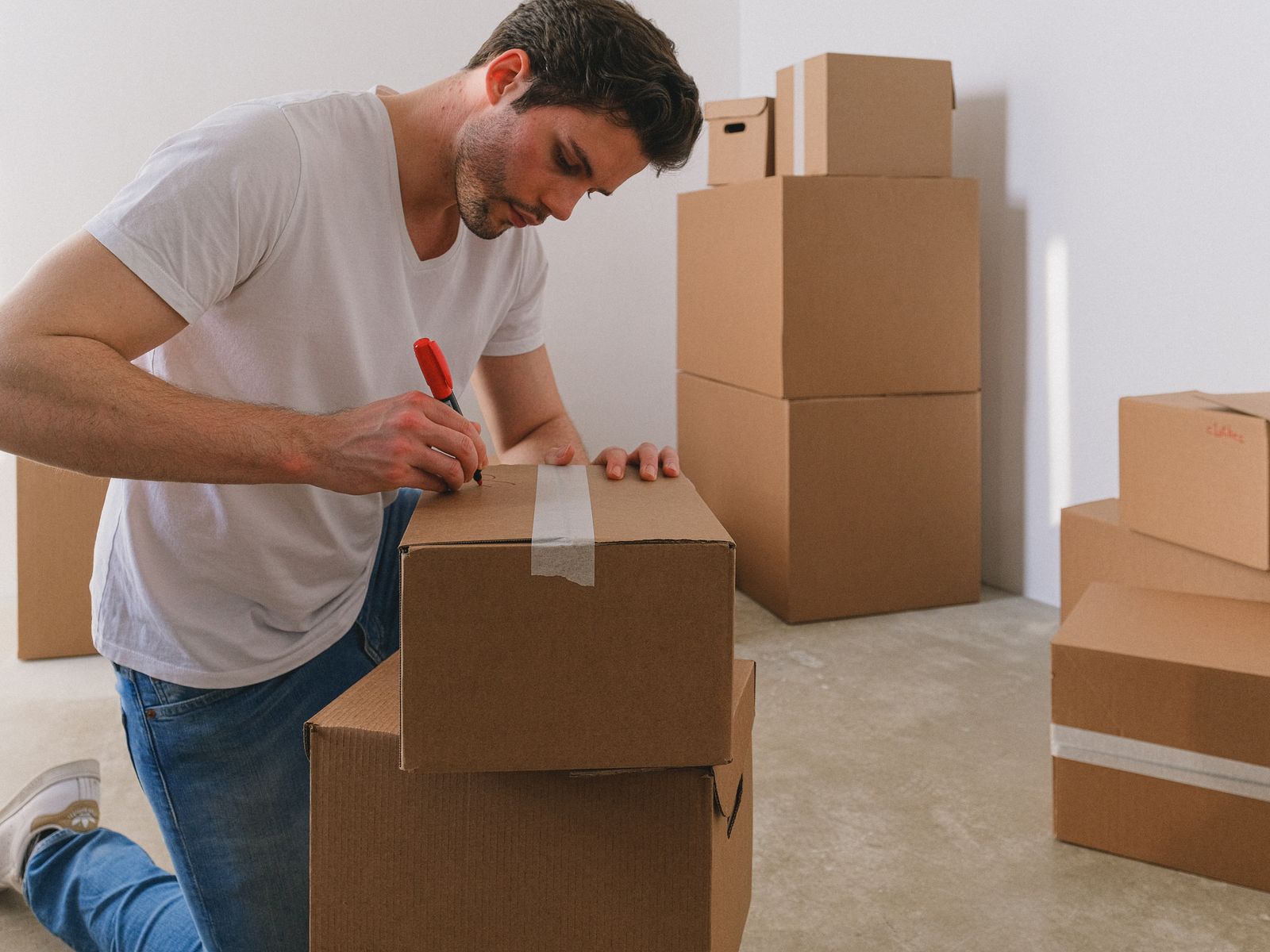 Labeling cardboard boxes by room while packing an apartment
