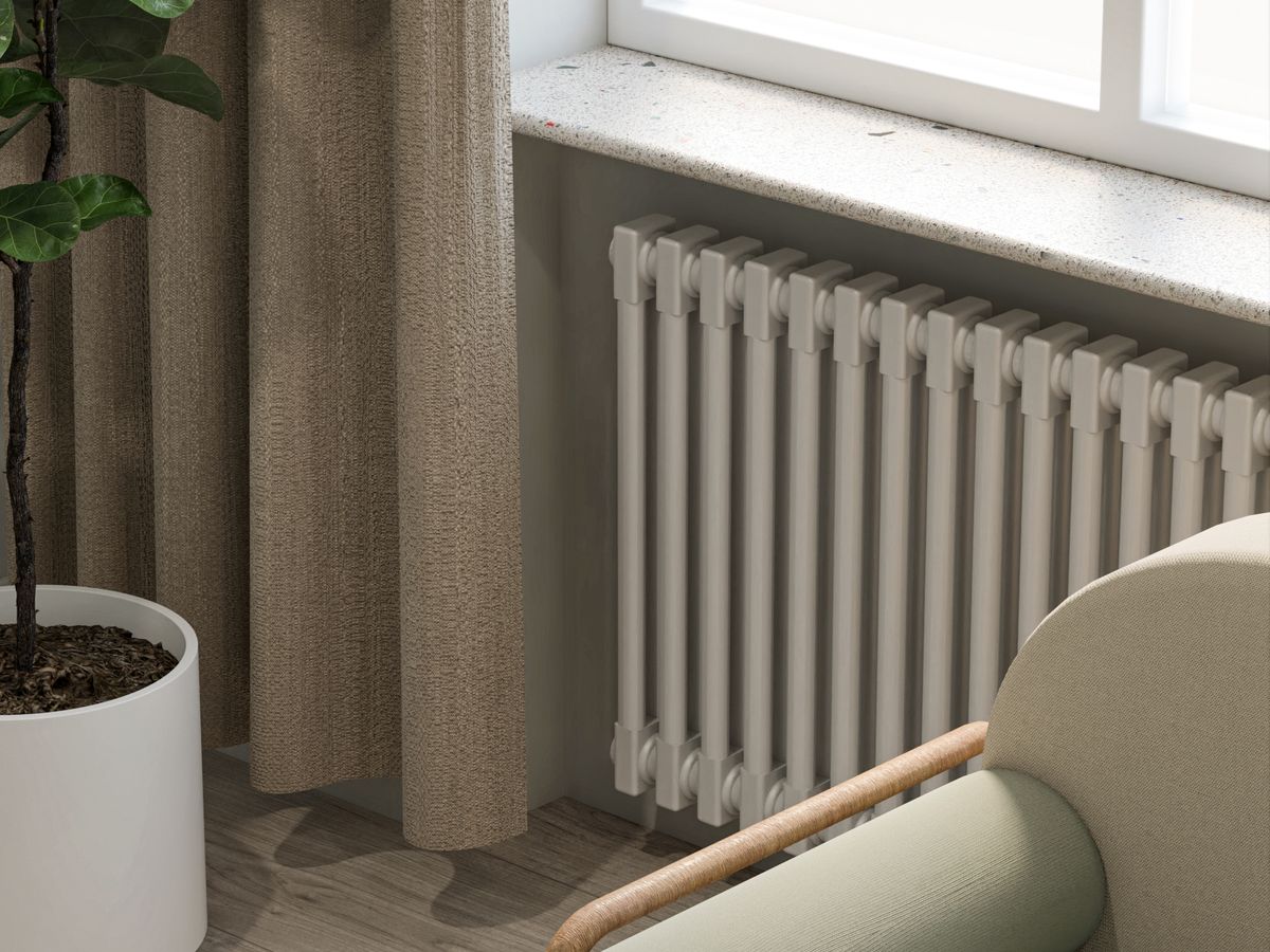 A freestanding cover and plant used to hide ugly radiators in a rental