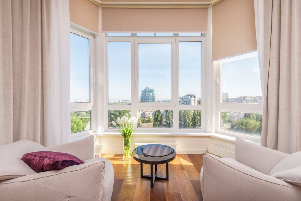 Bright apartment living room with large windows and sheer curtains, ideal for removable window film