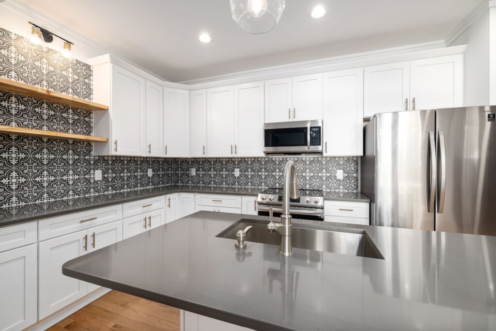 A kitchen with white cabinets and a tiled wall, a rental kitchen backsplash renters can update