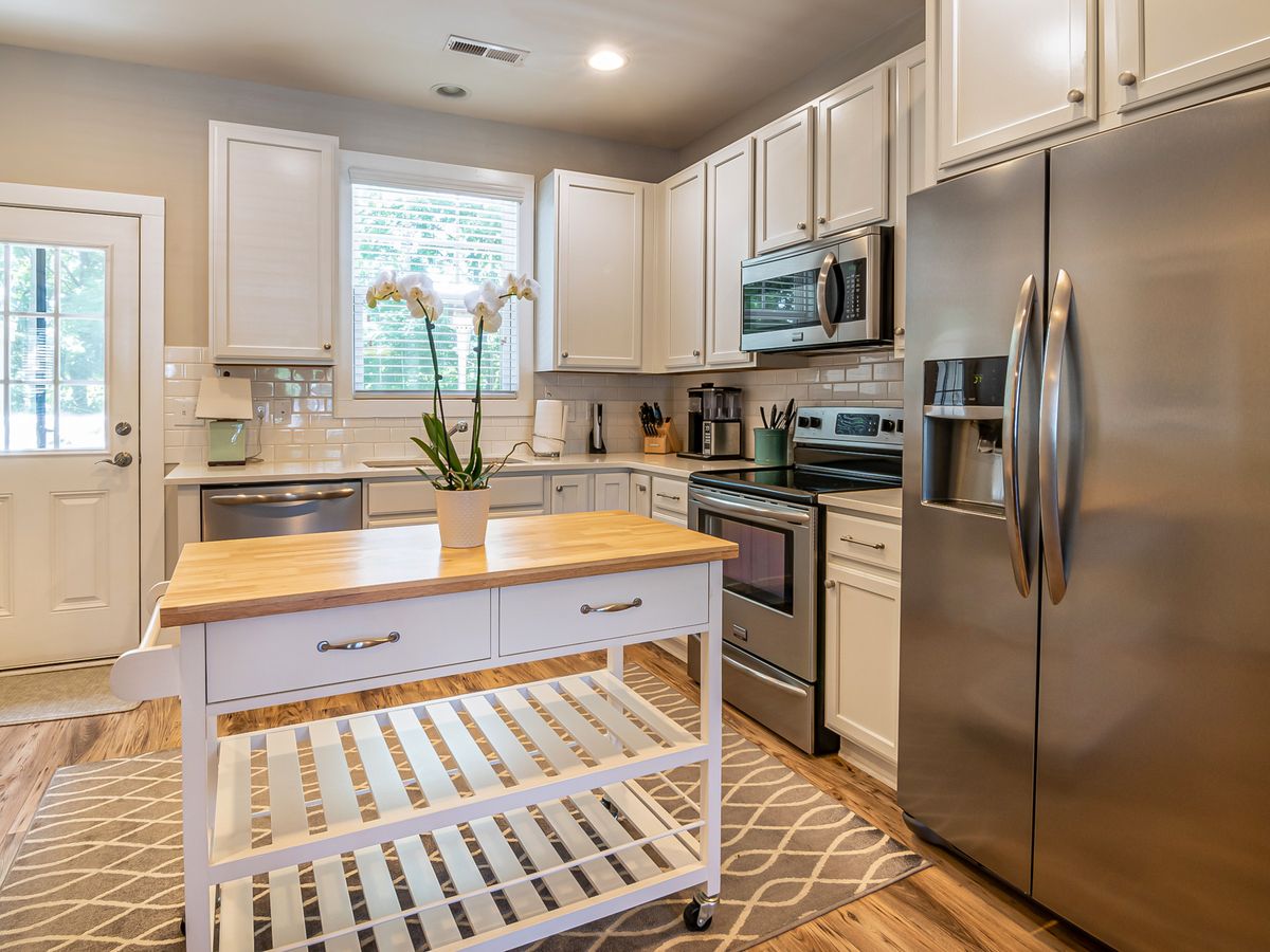 Freestanding wooden kitchen island cart adding counter and storage space in a rental kitchen