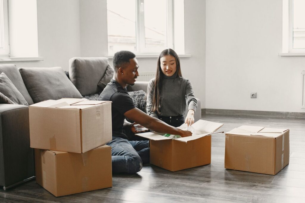 Couple unpacking moving boxes as they settle into a new rental apartment