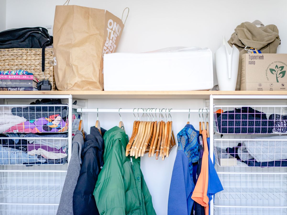 An open wardrobe organized to share a small rental closet fairly