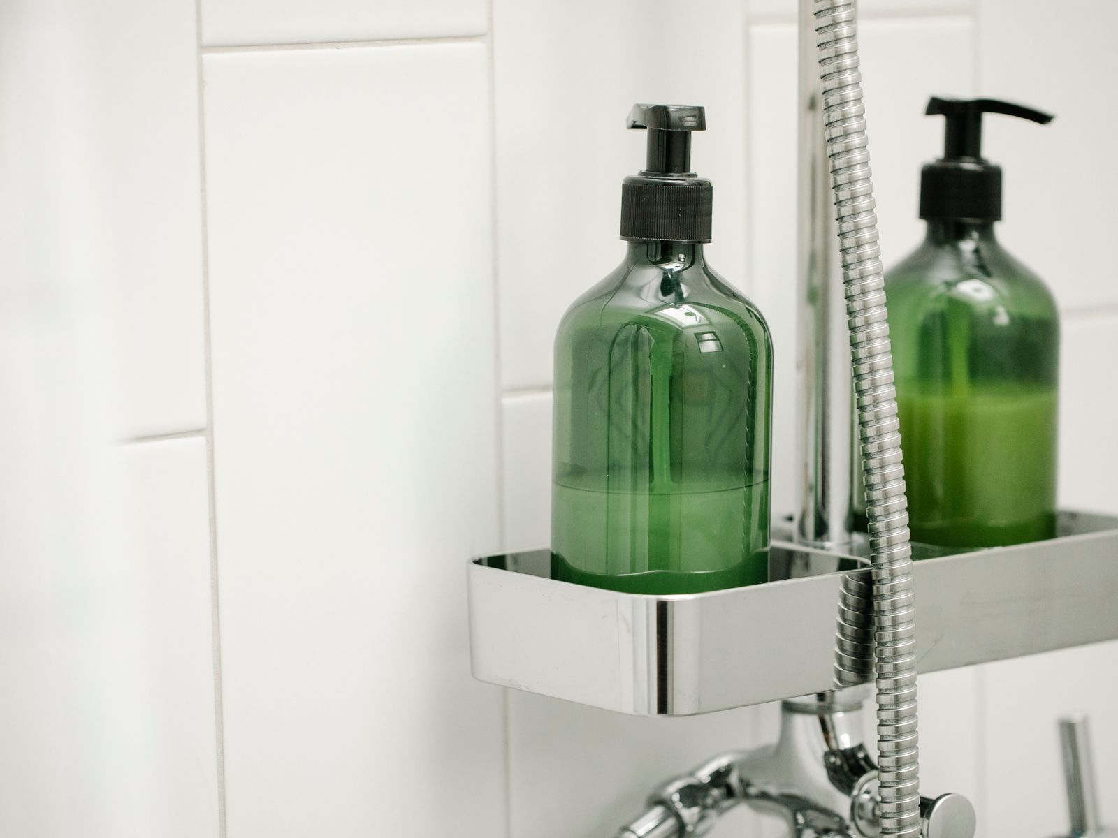 Bottles on a shower shelf showing no-drill bathroom storage in the shower