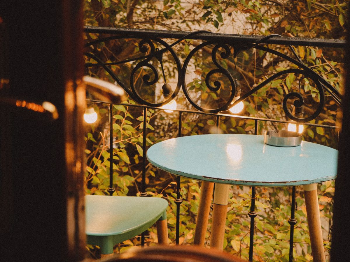 Small balcony setup with a table, chair and plants using vertical space for renter-friendly balcony and garage storage