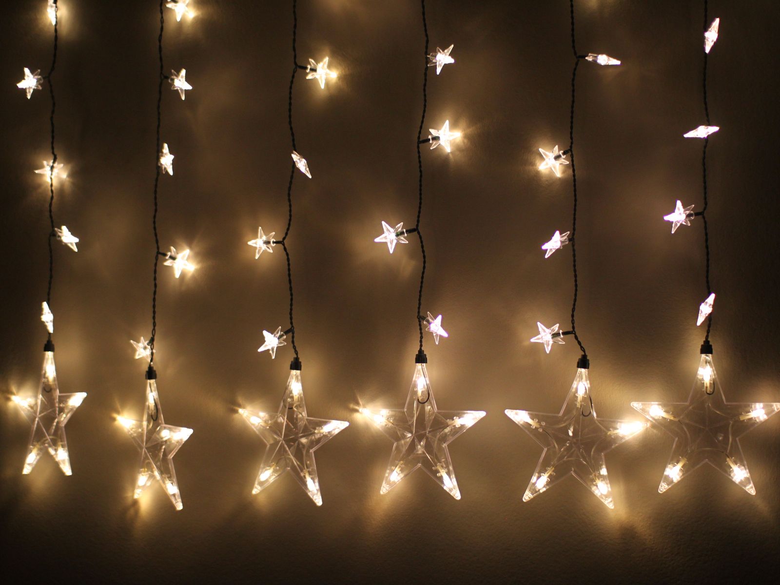 Star-shaped string lights hung along a wall in a rental without drilling