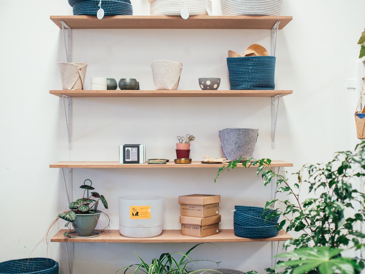 Styled open shelving with fabric baskets, dishware and plants showing intentional storage