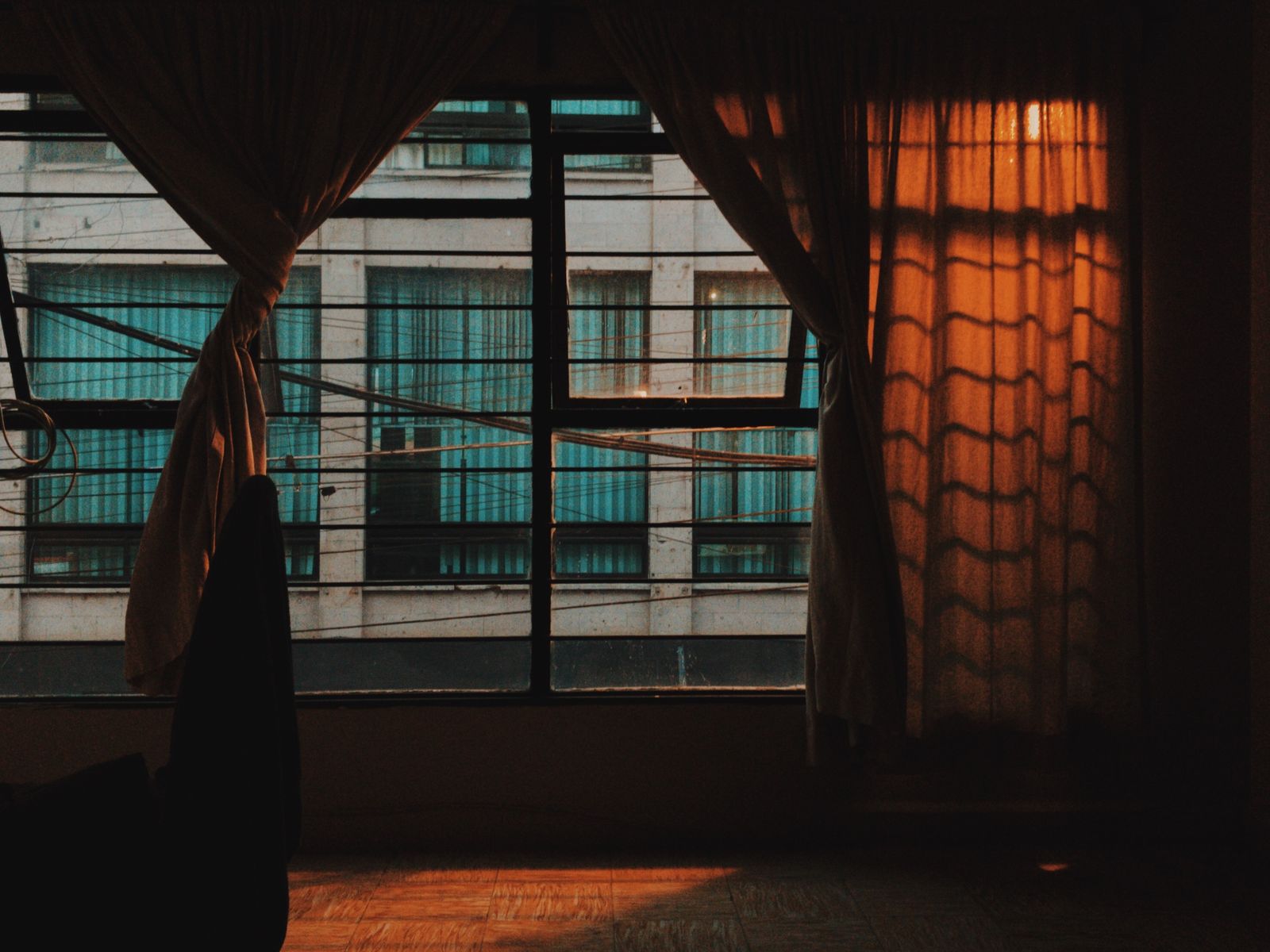 Curtains hung without drilling letting sunset light into an apartment