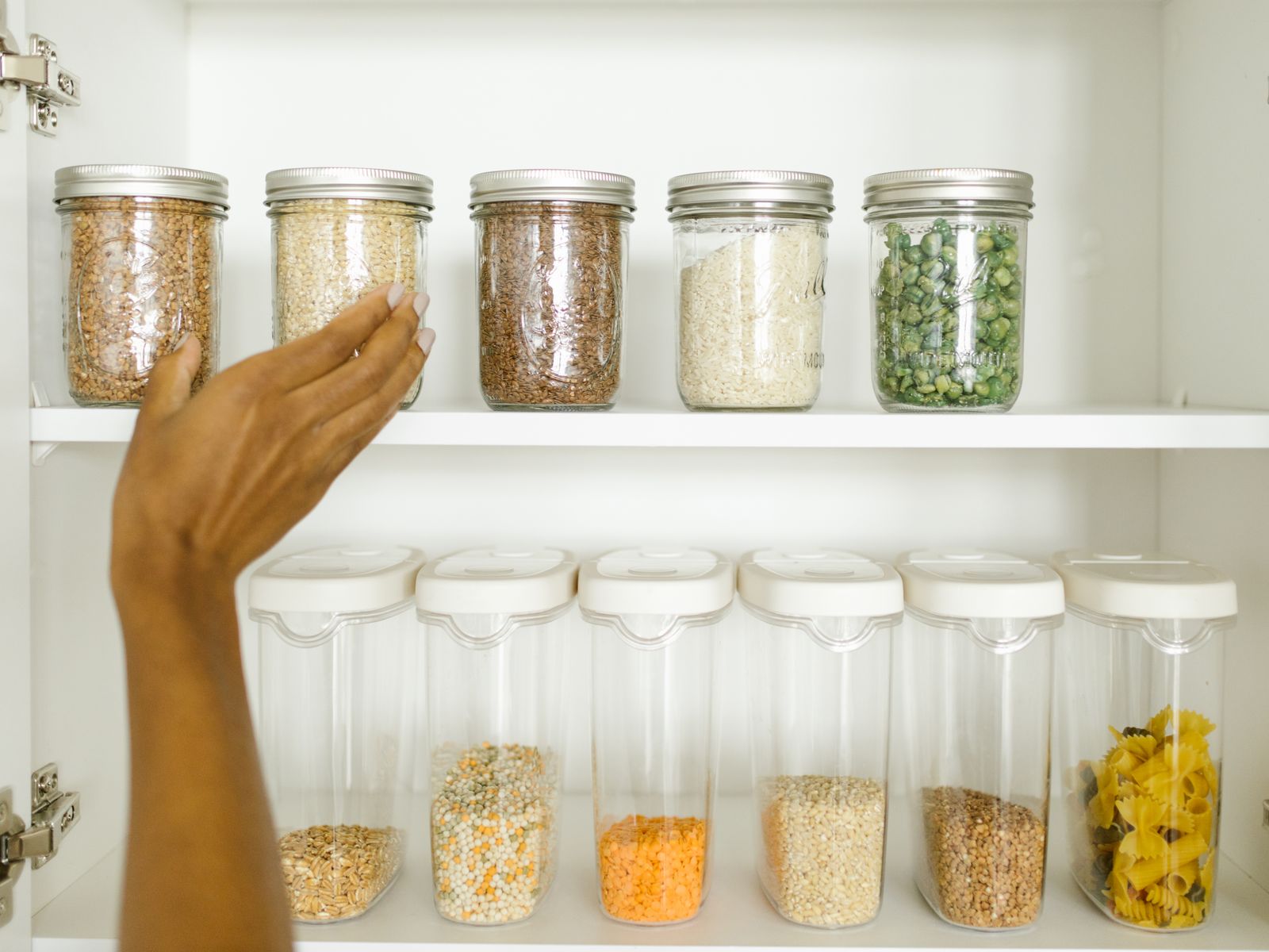 Tension rods dividing organized pantry shelves