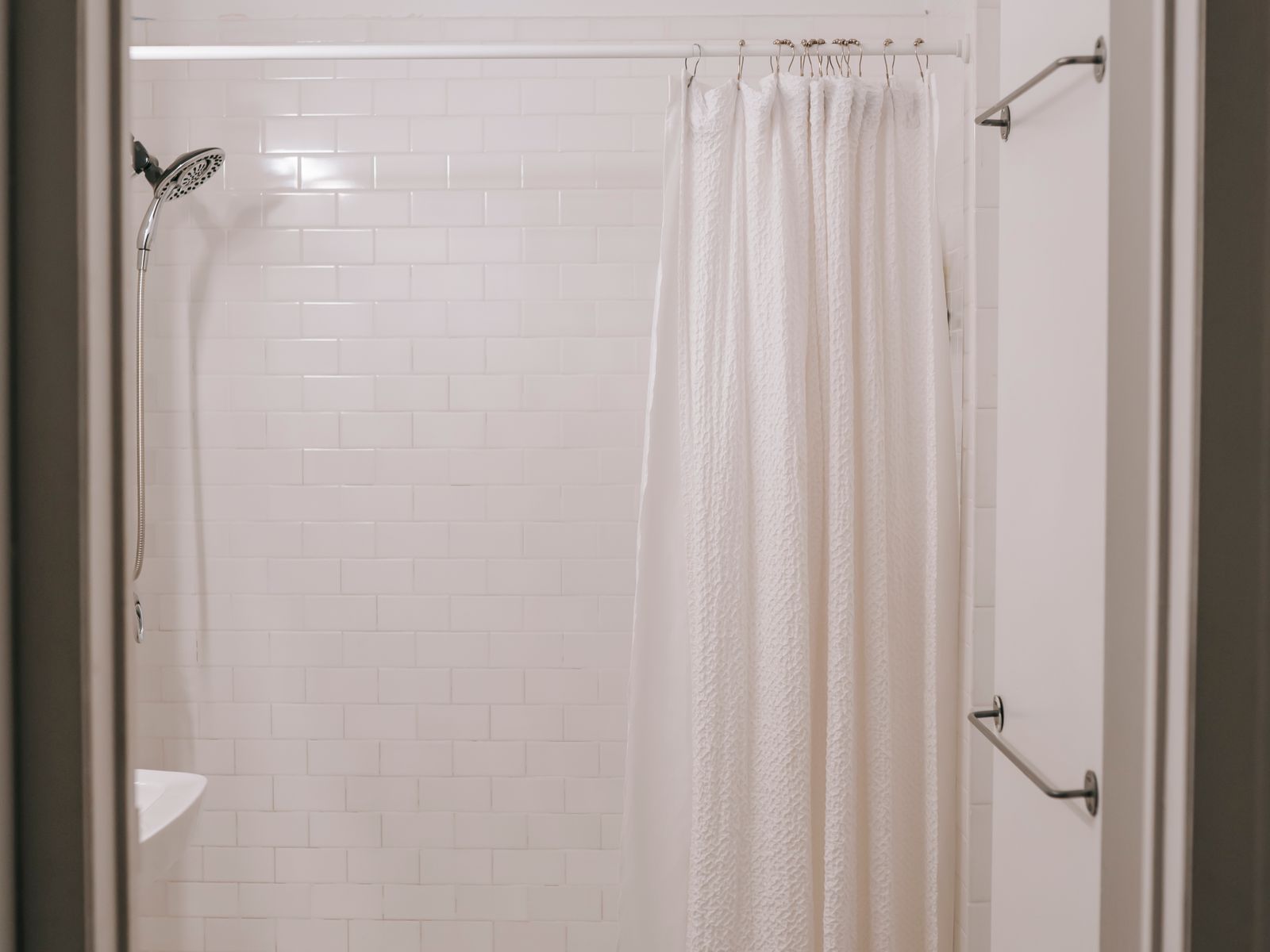 Tension rod holding a shower curtain in a rental bathroom