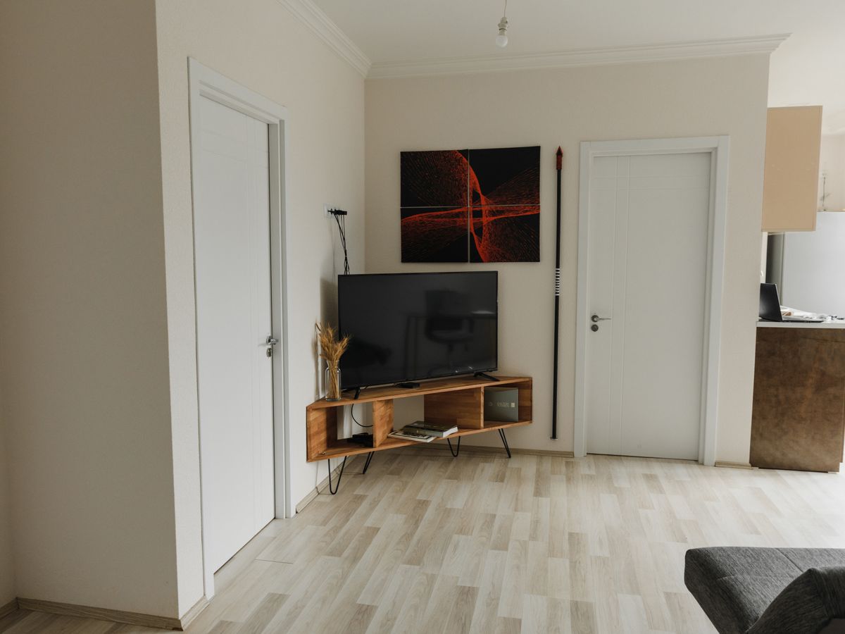 Flat screen TV on a low wooden media console in an apartment living room