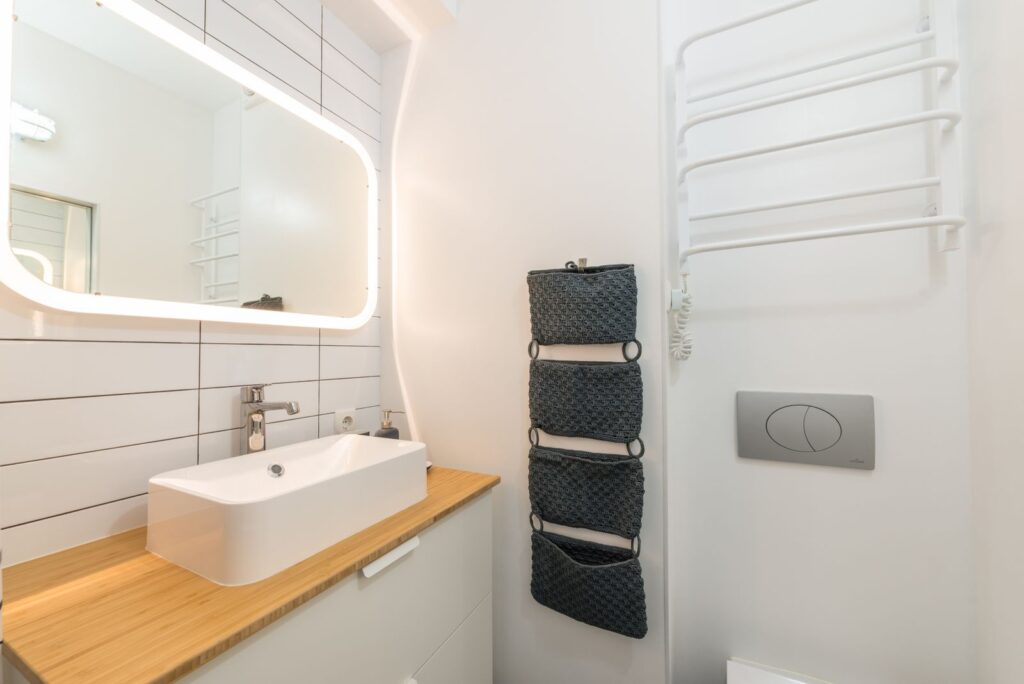 Rental bathroom sink on a white cabinet with storage space under the sink