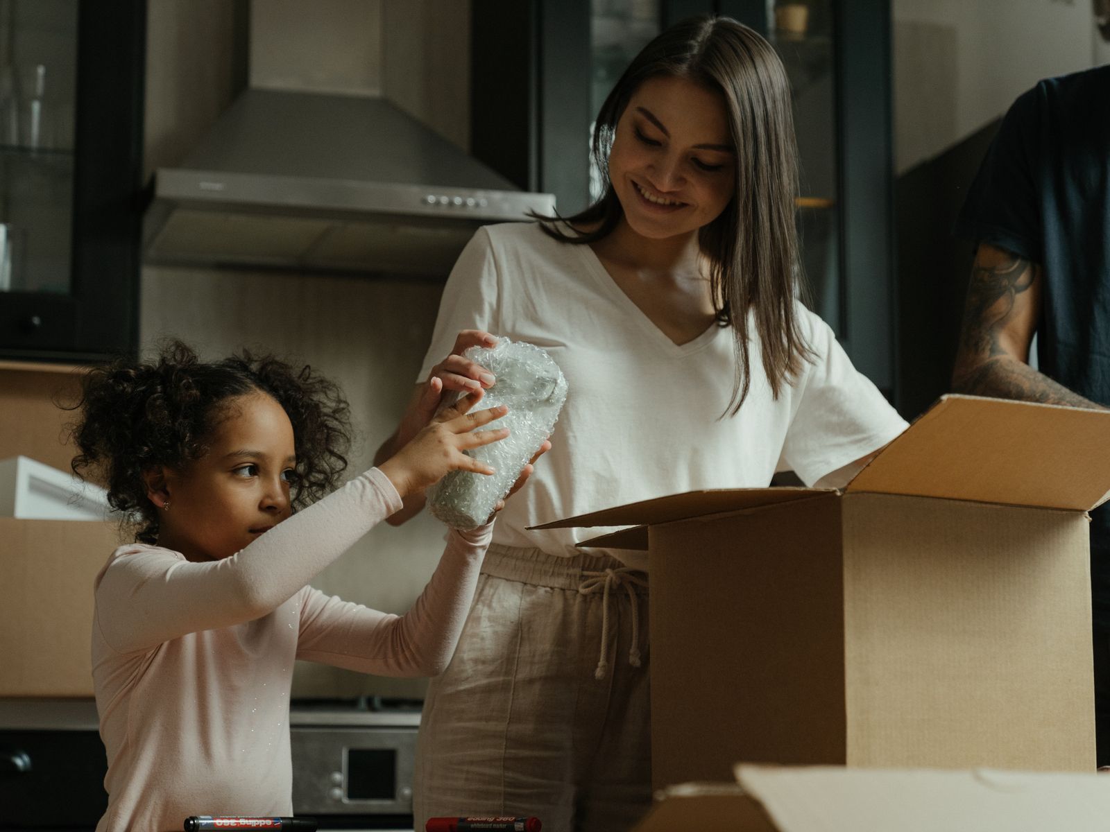 Family unpacking boxes in the kitchen of a new rental home
