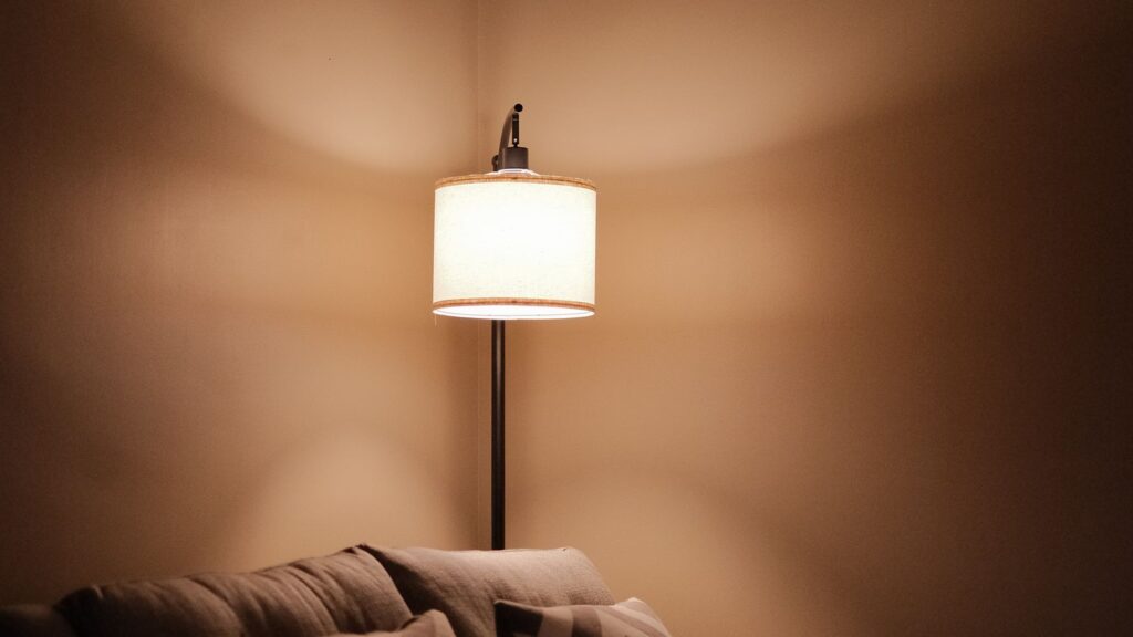 A warm lamp glow used to upgrade rental lighting in a cozy living room