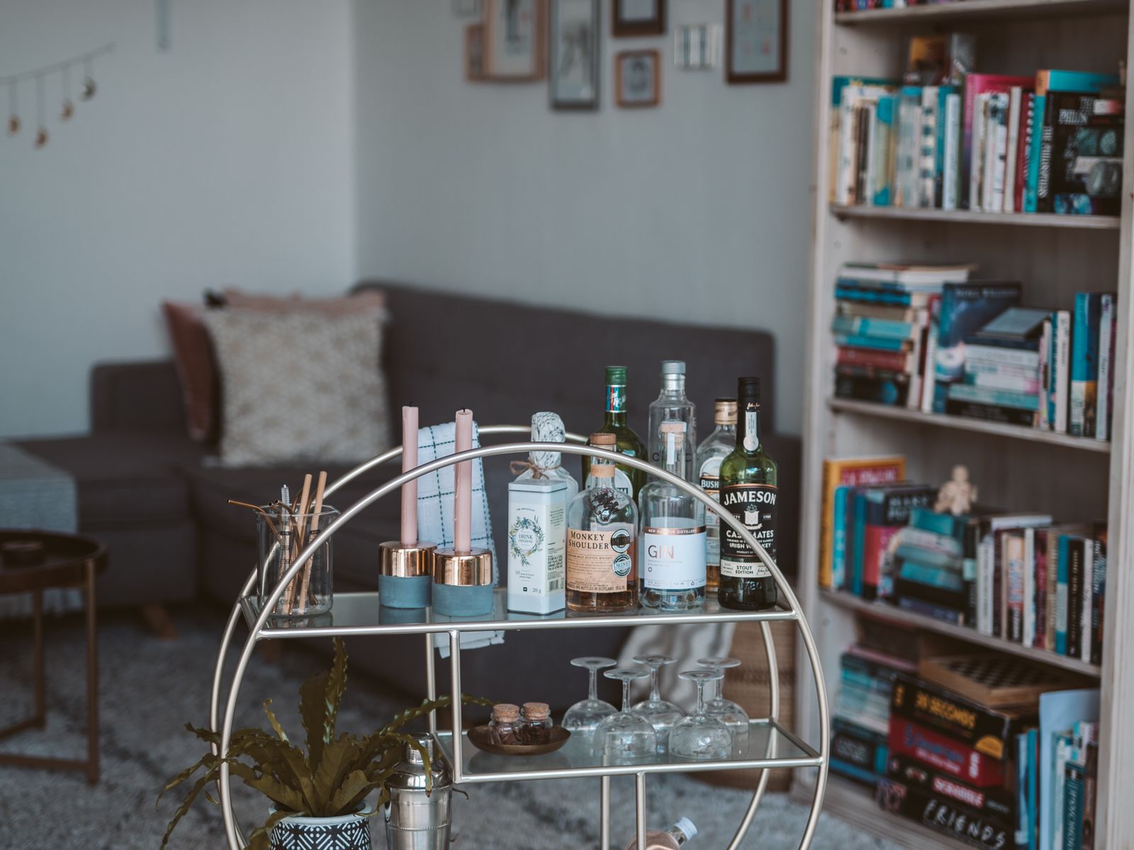 Styled cart used as vertical storage in a rental living room