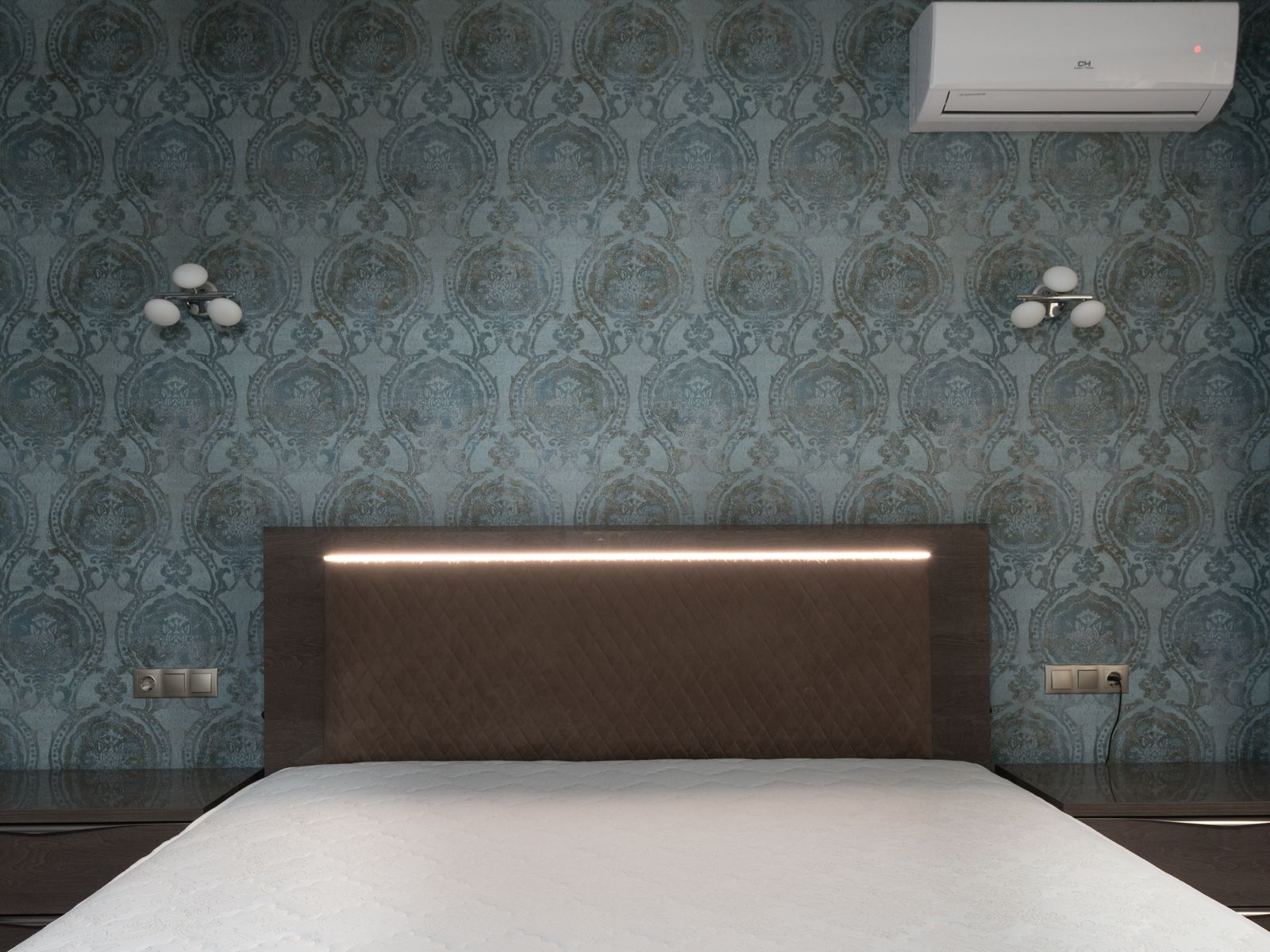 Patterned wallpaper on the wall behind a bed in a rental bedroom