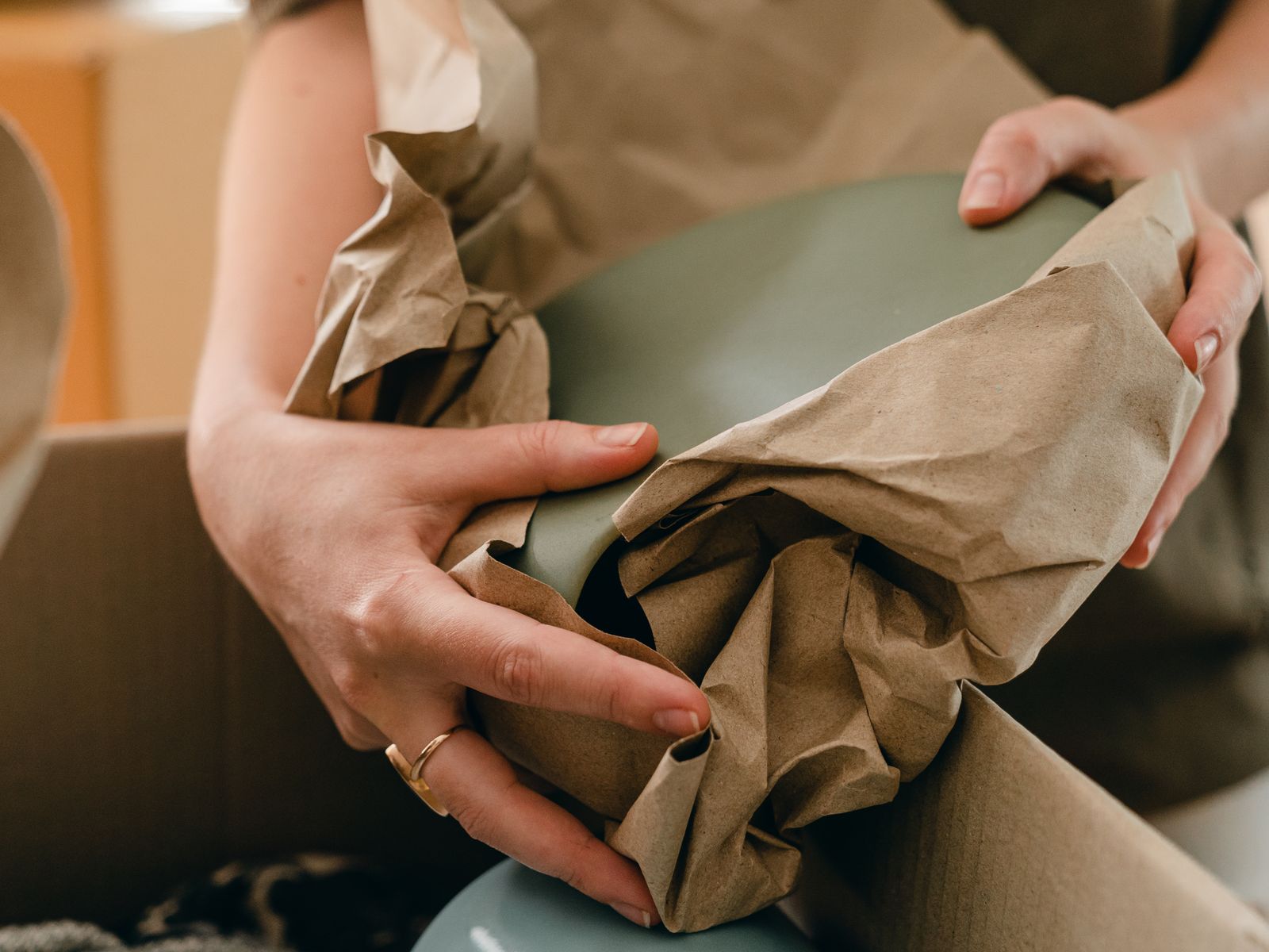 Person wrapping fragile items in packing paper before a move